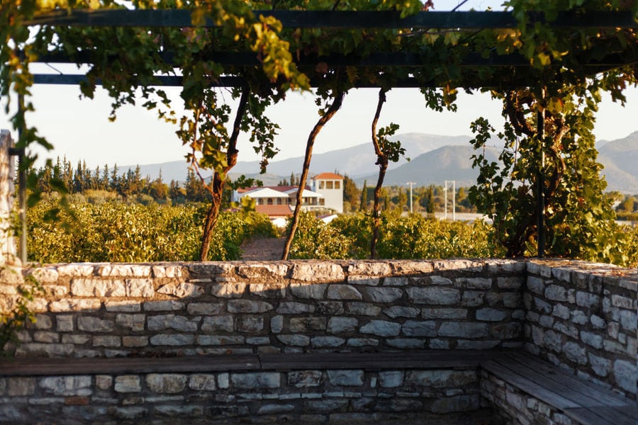 wooden pavilion and stone wall front Chateau Kaniaris winery vineyards